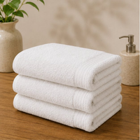 Stack of white towels on a wooden surface with a blurred background