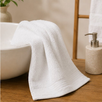 White towel draped over a white bowl on a wooden surface with a neutral background