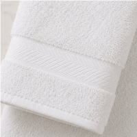 Close-up of a white towel with textured surface on a light gray background